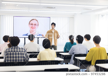 College student listening to a foreigner connected online College student listening to a foreigner connected online 97453286
