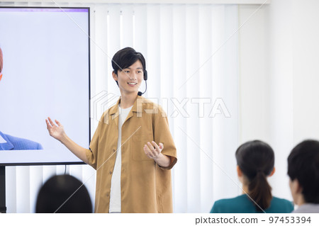 Seminar A man speaking with a head microphone 97453394