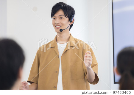 Seminar A man speaking with a head microphone Seminar A man speaking with a head microphone 97453400