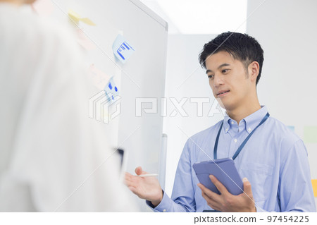 Meeting A man talking while looking at a tablet 97454225