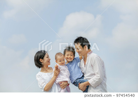 Family of four walking on the park promenade Family of four walking on the park promenade 97454540