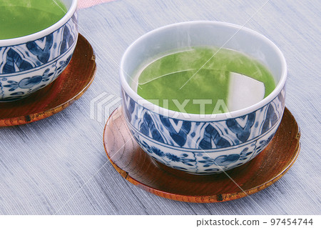 溫暖的綠茶湧入茶杯 溫暖的綠茶湧入茶杯 97454744