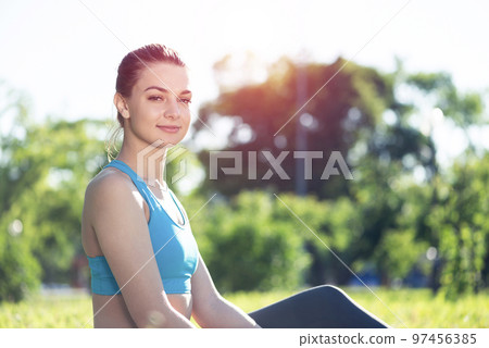 Beautiful smiling girl in sportswear relax in park Beautiful smiling girl in sportswear relax in park 97456385