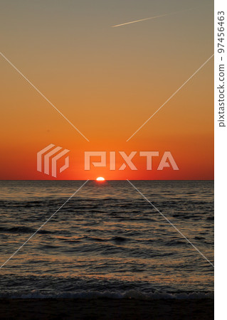 Contrails and the setting sun at dusk Contrails and the setting sun at dusk 97456463