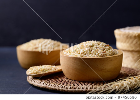 Organic Thai brown rice grain in wooden bowl on black background, Asian healthy food ingredients Organic Thai brown rice grain in wooden bowl on black background, Asian healthy food ingredients 97456580