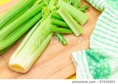 Fresh Celery Stem and Chopped Celery Sticks on Wooden Cutting Board Fresh Celery Stem and Chopped Celery Sticks on Wooden Cutting Board 97456803