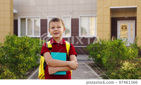 teenage boy with textbook his hands smiles. portrait happy schoolboy with book. educational school program for children. cheerful kid boy school yard. student with school backpack his back. close-up. 97461366