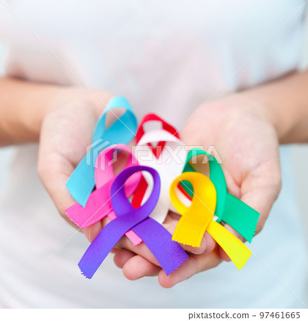 World cancer day, February 4. Hand holding blue, red, teal, white, pink, purple and yellow ribbons for supporting people living and illness. Healthcare and Autism awareness day concept 97461665