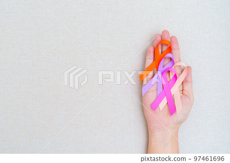 World cancer day, February 4. Hand holding orange, pink, peach and purple ribbons for supporting people living and illness. Healthcare and medical concept World cancer day, February 4. Hand holding orange, pink, peach and purple ribbons for supporting people living and illness. Healthcare and medical concept 97461696