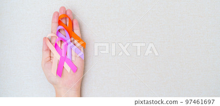 World cancer day, February 4. Hand holding orange, pink, peach and purple ribbons for supporting people living and illness. Healthcare and medical concept World cancer day, February 4. Hand holding orange, pink, peach and purple ribbons for supporting people living and illness. Healthcare and medical concept 97461697