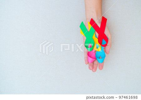 World cancer day, February 4. Hand holding blue, red, green, pink and yellow ribbons for supporting people living and illness. Healthcare and Autism awareness day concept World cancer day, February 4. Hand holding blue, red, green, pink and yellow ribbons for supporting people living and illness. Healthcare and Autism awareness day concept 97461698