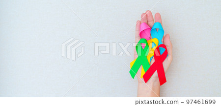 World cancer day, February 4. Hand holding blue, red, green, pink and yellow ribbons for supporting people living and illness. Healthcare and Autism awareness day concept World cancer day, February 4. Hand holding blue, red, green, pink and yellow ribbons for supporting people living and illness. Healthcare and Autism awareness day concept 97461699