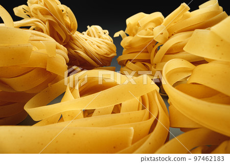 Dry pasta on dark background macro photo 97462183