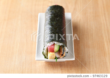Eho-maki served on a plate (Ingredients: tuna, boiled conger eel, cucumber, omelet, perilla, shrimp.) 97463129