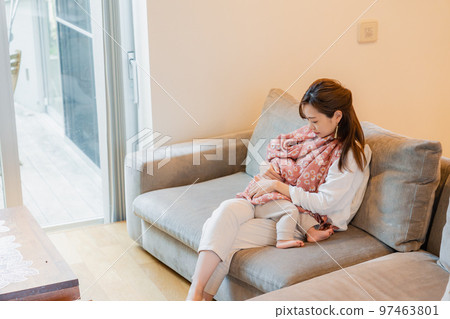 mother breastfeeding baby on sofa mother breastfeeding baby on sofa 97463801