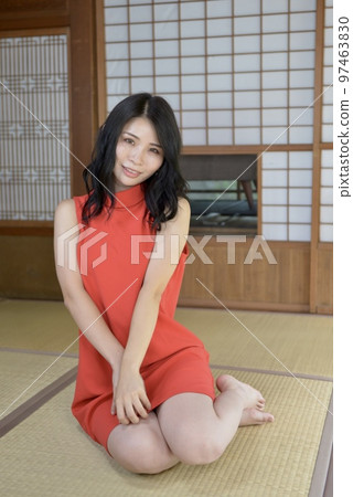 A young woman in a one-piece swimsuit sitting in a Japanese-style room in an old folk house 97463830