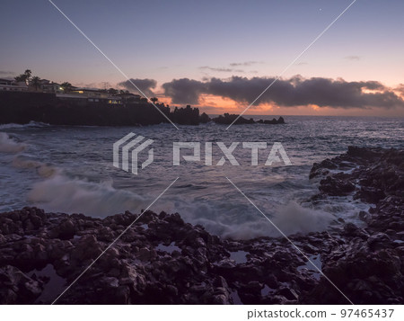 Sunset view of black sand beach Playa de la Arena with dramat orange clouds and sharp lava rock. Santiago del Teide, Tenerife, Canary Islands, Spain. Sunset view of black sand beach Playa de la Arena with dramat orange clouds and sharp lava rock. Santiago del Teide, Tenerife, Canary Islands, Spain. 97465437