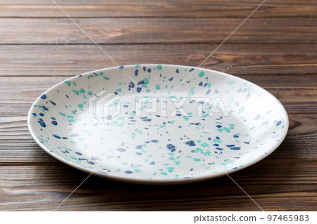 Perspective view of empty colorful plate on wooden background. Empty space for your design Perspective view of empty colorful plate on wooden background. Empty space for your design 97465983