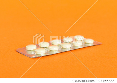 Blister package with Vitamin on color background. Medicine pills on a light background. Medicines and prescription pills flat lay background. yellow medical tablets in blister 97466222