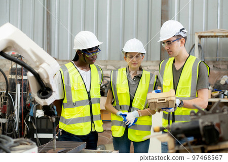 Team engineer man and woman talking and explaining about robot arms technology. 97468567