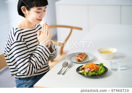 Woman starting a meal in the dining room at home Woman starting a meal in the dining room at home 97468728