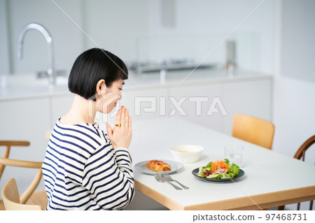 Woman starting a meal in the dining room at home 97468731