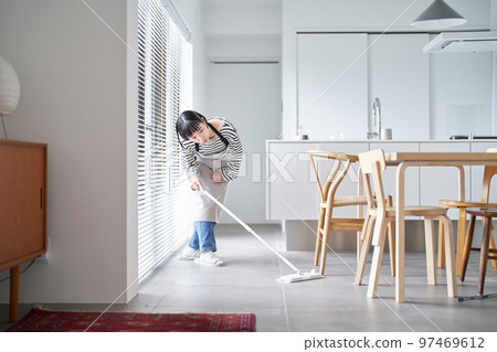 在房間裡打掃地板的年輕女人 97469612