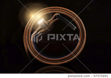 Leather brown belt on a dark background with reflection. 97470891