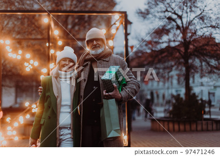 Happy senior couple enjoying christmas market, buying gifts. 97471246