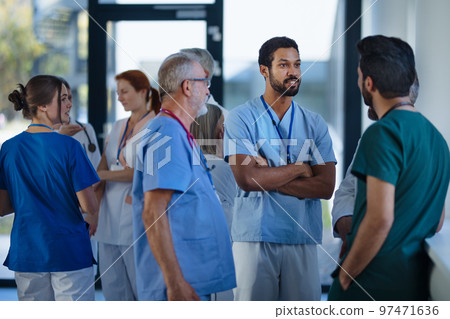 Doctors and nurses talking together at hospital corridor. 97471636