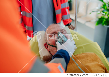 Rescuers taking care of patient from ambulance, close-up. 97471712