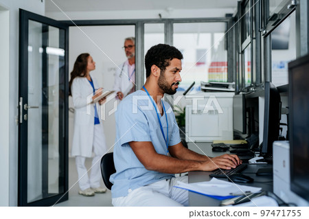 Young doctor working on computer in his office. Young doctor working on computer in his office. 97471755