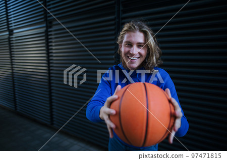 Portrait of young man with cap and sunglasses holding basketball ball,outdoor in city. Youth culture. 97471815