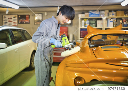 Young auto mechanic working in a factory Young auto mechanic working in a factory 97471880