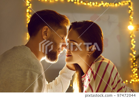 Happy young couple in love kissing during romantic date on Valentine's Day at home Happy young couple in love kissing during romantic date on Valentine's Day at home 97472044