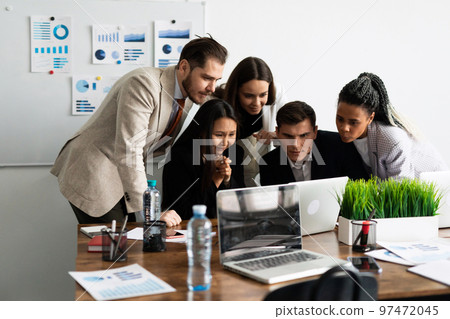 Marketing team. Group of young modern people in smart casual wear discussing something while working 97472045