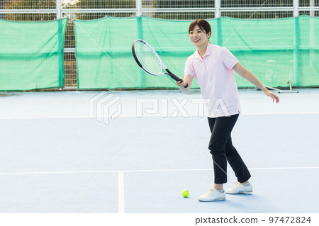 A woman enjoying tennis A woman enjoying tennis 97472824