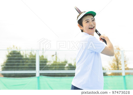 Middle-aged women enjoying tennis Middle-aged women enjoying tennis 97473028