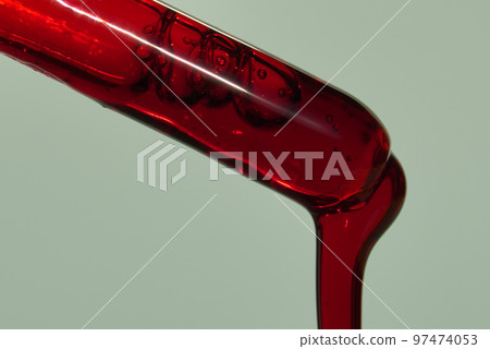 A drop of blood or other red liquid from a glass pipette. The concept of a blood test study with a copy space. High quality photo A drop of blood or other red liquid from a glass pipette. The concept of a blood test study with a copy space. High quality photo 97474053