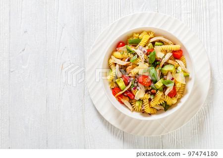 Healthy Chicken Pasta Salad with Avocado, Tomato, and olive oil and vinegar dressing in white bowl on white wood table Healthy Chicken Pasta Salad with Avocado, Tomato, and olive oil and vinegar dressing in white bowl on white wood table 97474180