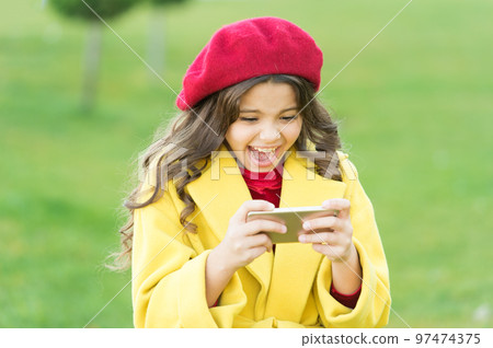 Shocking content. Little girl using mobile phone. Small girl child checking news feed. Surfing internet. Social networks. Mobile internet. Child learning new technology. Watching video mobile device 97474375