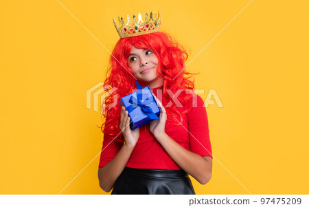 glad child in crown with gift box on yellow background 97475209