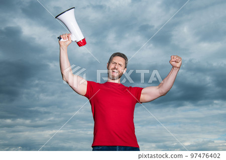 man in red shirt with loudspeaker on sky background 97476402