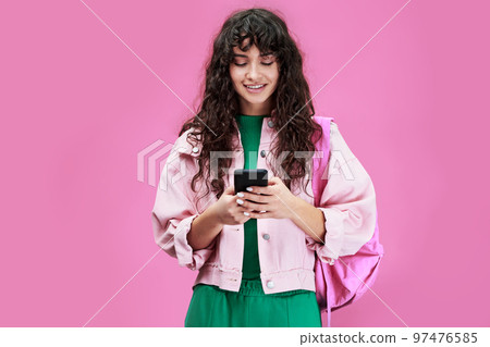 Young modern student in denim jacket looking at screen of mobile phone 97476585