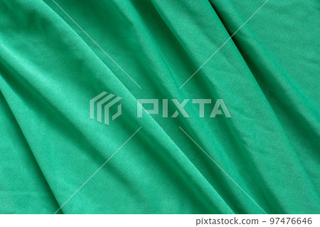 Green fabric texture with beautiful waves. Diagonal waves. Thin soft textile. Green fabric texture with beautiful waves. Diagonal waves. Thin soft textile. 97476646