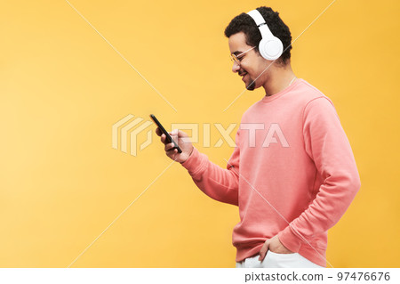 Side view of happy young multi-ethnic man with smartphone 97476676