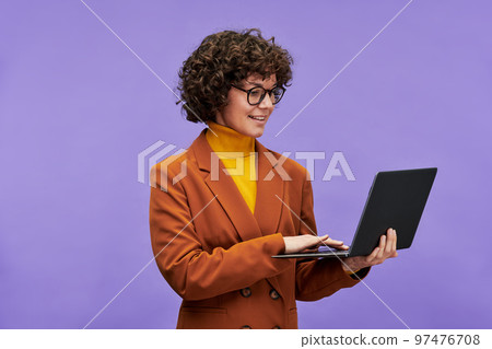 Young confident teacher or chief executive officer using laptop Young confident teacher or chief executive officer using laptop 97476708