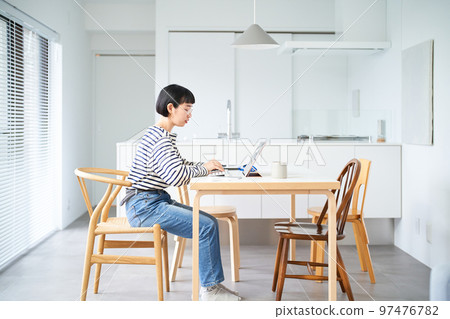 Young woman working at table in room 97476782