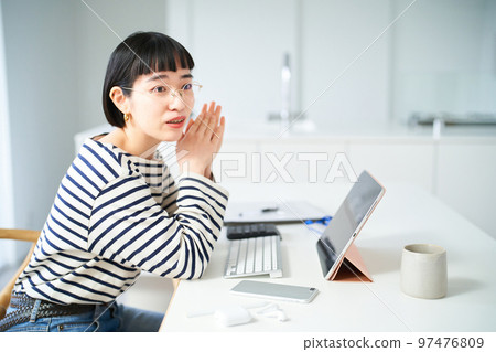 在房間裡的桌子旁工作的年輕女人 在房間裡的桌子旁工作的年輕女人 97476809