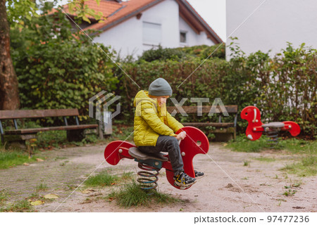 Funny cute happy baby playing on the playground. The emotion of happiness, fun, joy. Smile of a child. boy playing on the playground Funny cute happy baby playing on the playground. The emotion of happiness, fun, joy. Smile of a child. boy playing on the playground 97477236